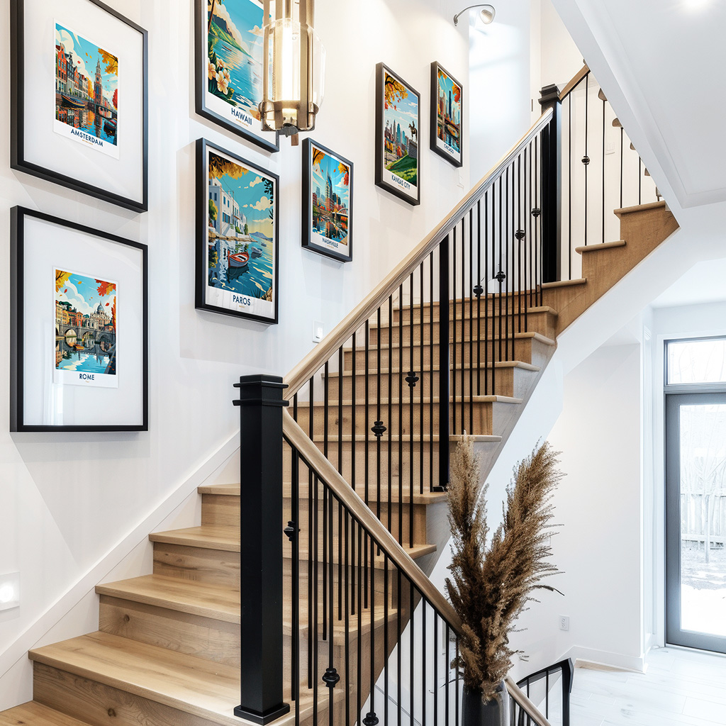 A staircase with framed art prints displayed on the wall, showcasing various colorful scenes.