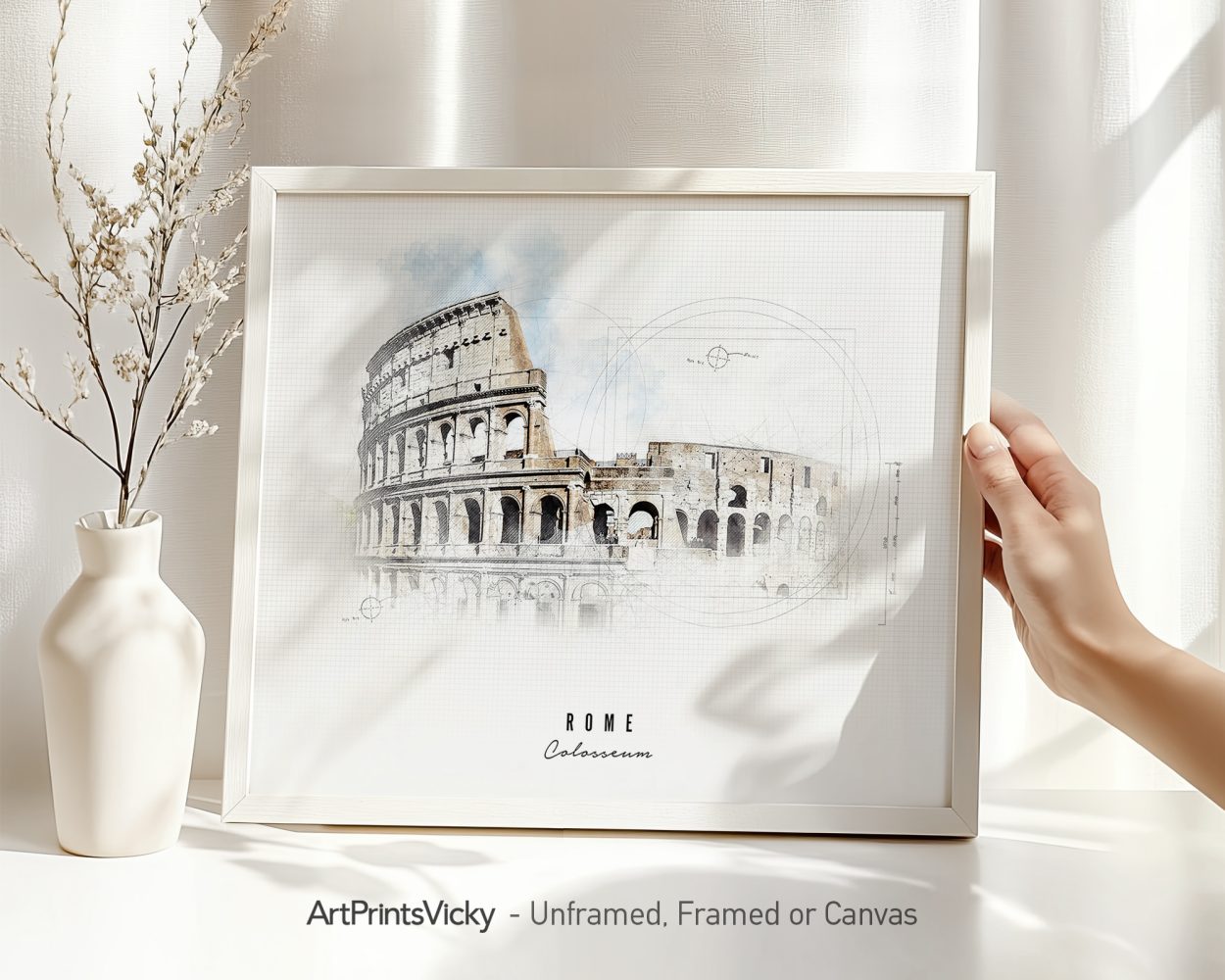 Framed artwork of the Colosseum in Rome with a hand holding it and a vase in the background.