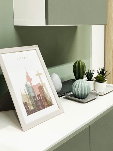 Framed artwork depicting a stylized skyline of Lisbon with various architectural elements.