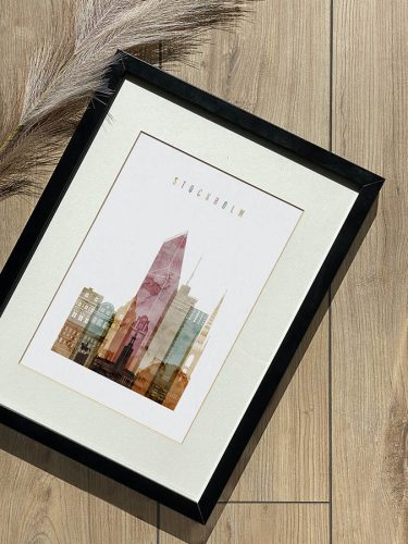 Framed print featuring a stylized cityscape of Stockholm with various buildings and a prominent tower.