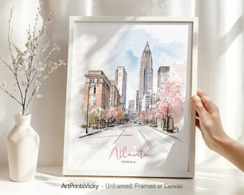 Hand holding a framed art print of Atlanta in watercolor drawing with soft pastel tones.