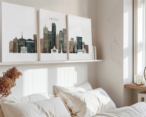 Three-panel artwork depicting a cityscape of Boston with muted colors on a shelf above a bed.