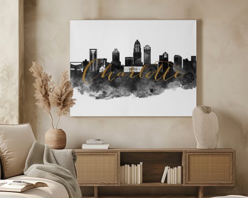 Black and white cityscape artwork of Charlotte with gold lettering on a wall.