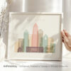 Framed artwork depicting the skyline of Charlotte with various building silhouettes and colors.