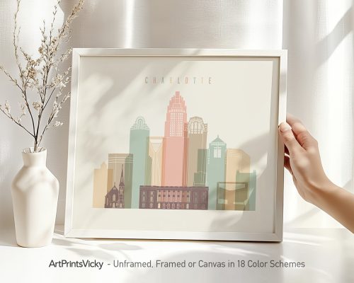 Framed artwork depicting the skyline of Charlotte with various building silhouettes and colors.