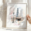 Hand holding a framed art print of Chicago in watercolor drawing with soft pastel tones.