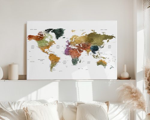 Watercolor world map with various colors representing different regions displayed on a wall.