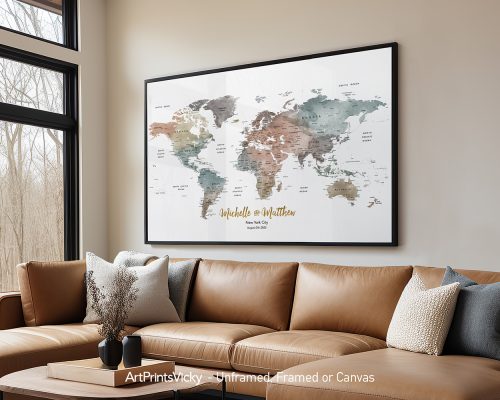 Framed world map artwork with muted colors and personalized text displayed on a wall above a couch.