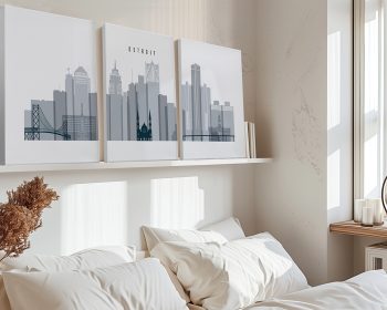 Three-panel artwork depicting the Detroit city skyline in gray tones displayed above a bed.