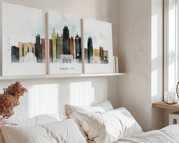 Three canvas prints depicting the skyline of Kansas City in muted colors on a shelf above a bed.