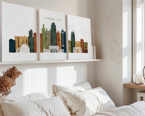 Three art prints depicting the skyline of Kansas City in muted colors on a shelf above a bed.