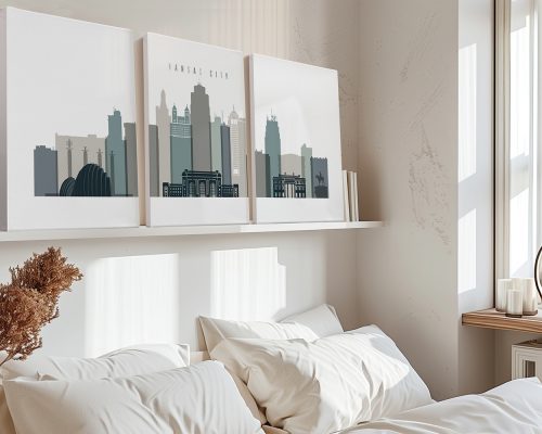 Three art prints depicting the skyline of Kansas City in muted colors displayed on a shelf.