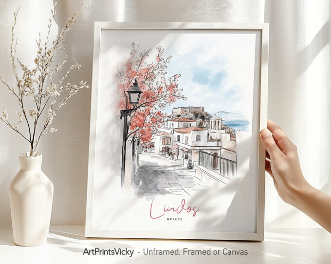 Framed artwork depicting a street scene in Lindos, Greece with pink trees and a historical building.