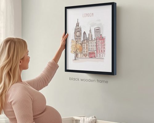 A woman touching a framed illustration of London cityscape with a clock tower and buildings.