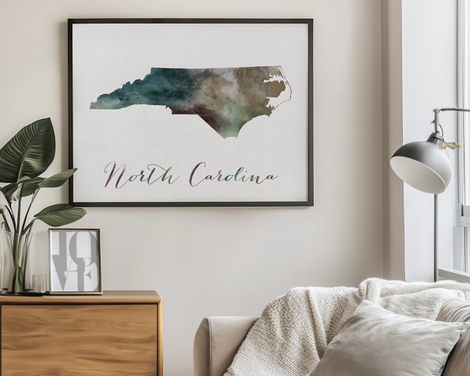 Framed artwork of the North Carolina state map with a watercolor design and text below.