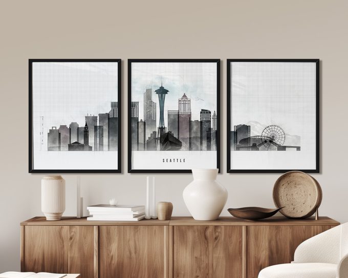 Three framed art prints depicting the Seattle skyline with the Space Needle and Ferris wheel.