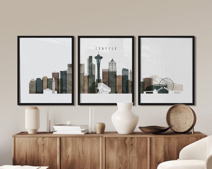 Three framed art prints depicting the Seattle skyline with notable landmarks.