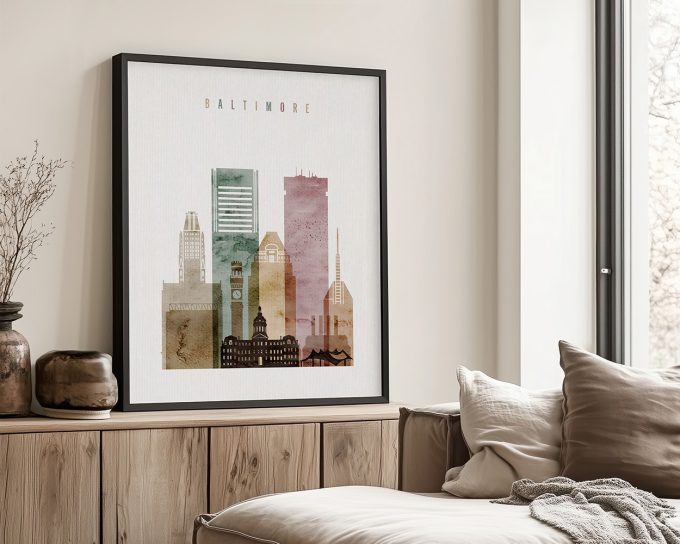 Framed artwork depicting the skyline of Baltimore with various building silhouettes in muted colors.