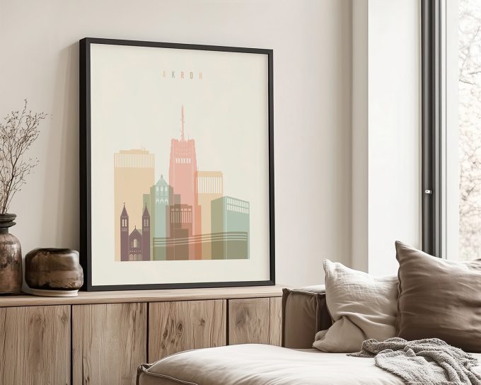 Framed artwork depicting a stylized cityscape of Akron with various buildings and colors.