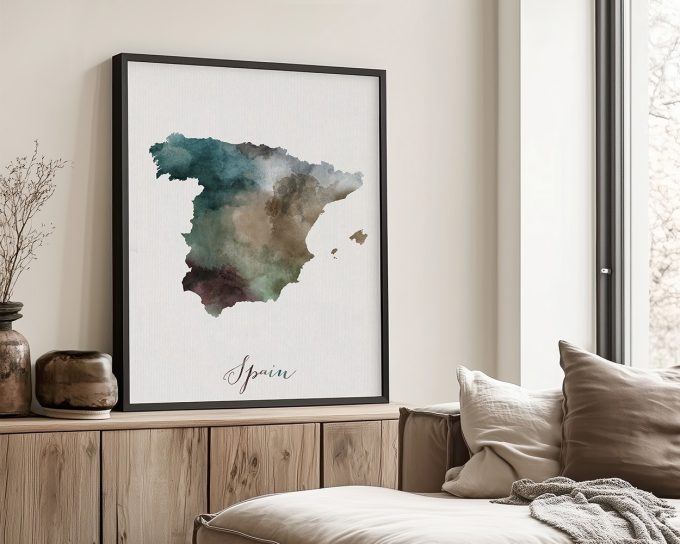 Watercolor illustration of Spain in shades of green, blue, and brown, framed and displayed on a wall.