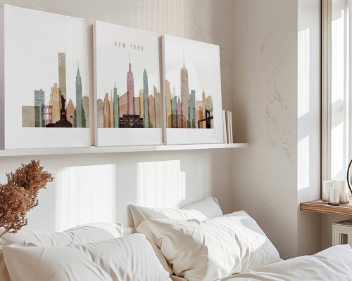 Three art prints of New York City skyline displayed on a shelf above a bed.