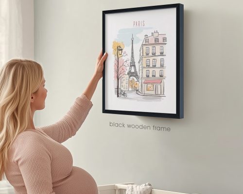 A woman touching a framed illustration of Paris featuring the Eiffel Tower and buildings.
