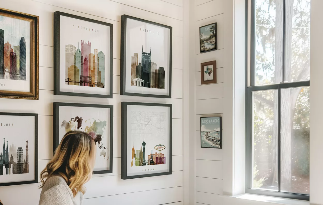Various framed cityscape prints displayed on a wall, featuring different cities and landmarks.