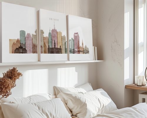 Three art prints depicting the skyline of Quebec City in soft colors displayed above a bed.