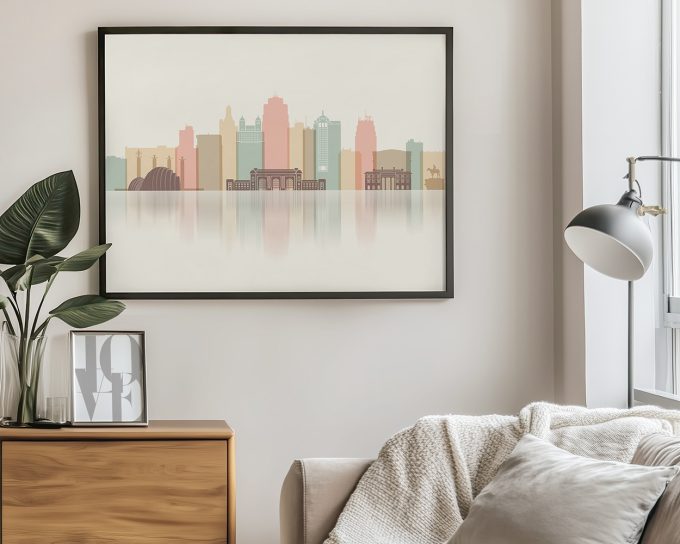 Framed minimalist cityscape artwork featuring buildings in soft colors displayed in a modern interior.