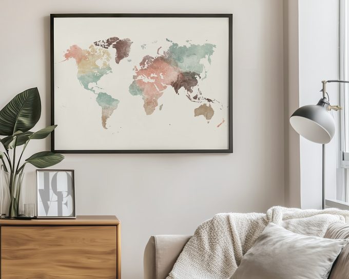 Artistic world map with watercolor effects in various colors, framed and displayed on a wall.