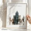Framed artwork depicting a cityscape of Amsterdam with notable buildings and landmarks.