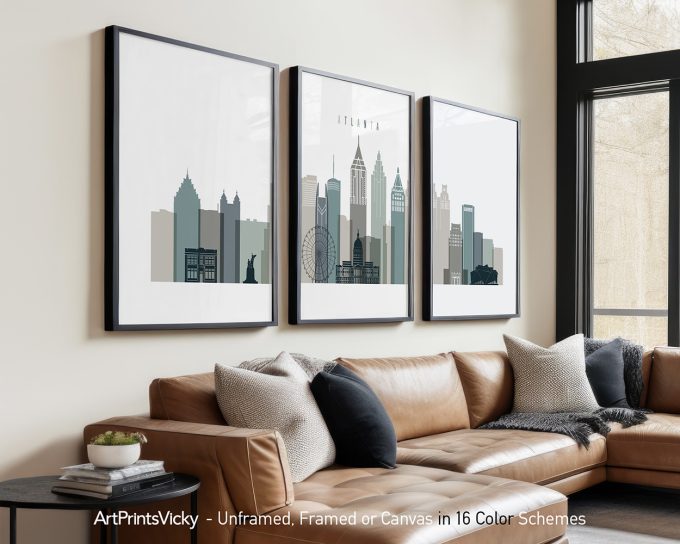 Three framed art prints of the Atlanta skyline displayed on a wall above a couch.