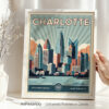 Framed artwork depicting the skyline of Charlotte, North Carolina with notable buildings and a river.