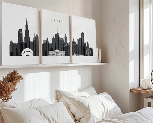 Three black and white art prints of the Chicago skyline displayed above a bed.