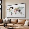 Watercolor world map artwork displayed in a frame on a wall above a couch.