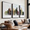 Three framed art prints of a Detroit cityscape displayed on a wall above a sofa.