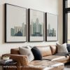 Three framed art prints of the Kansas City skyline displayed on a wall.