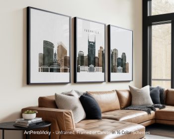 Three framed art prints of Nashville's skyline displayed on a wall above a sofa.