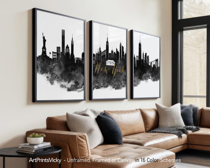 Three framed art prints of the New York City skyline in black and white with gold text.