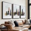 Three framed art prints depicting the skyline of New York City in various colors.