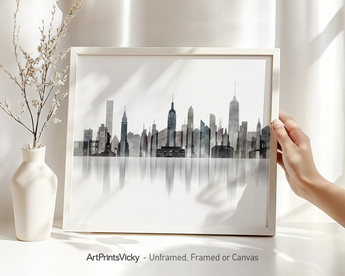 Framed artwork of the New York City skyline displayed with a hand holding it.
