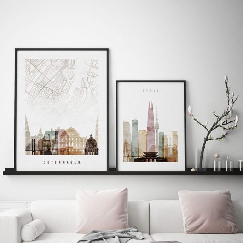 Two framed art prints featuring cityscapes of Copenhagen and Seoul displayed on a shelf.