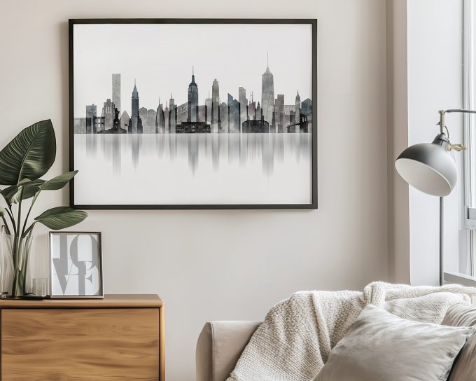 Framed artwork depicting a city skyline with various tall buildings and a reflective surface.