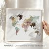 Artistic world map with watercolor effects in various colors displayed in a frame.