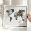 Artistic representation of a world map in muted colors displayed in a frame.