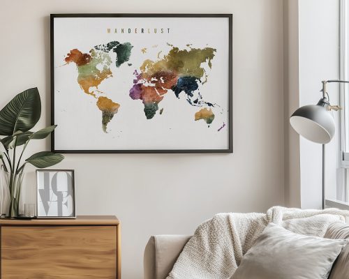 Colorful world map artwork framed and displayed on a wall with a plant and lamp nearby.