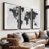 Three framed black and white world maps displayed on a wall above a couch.