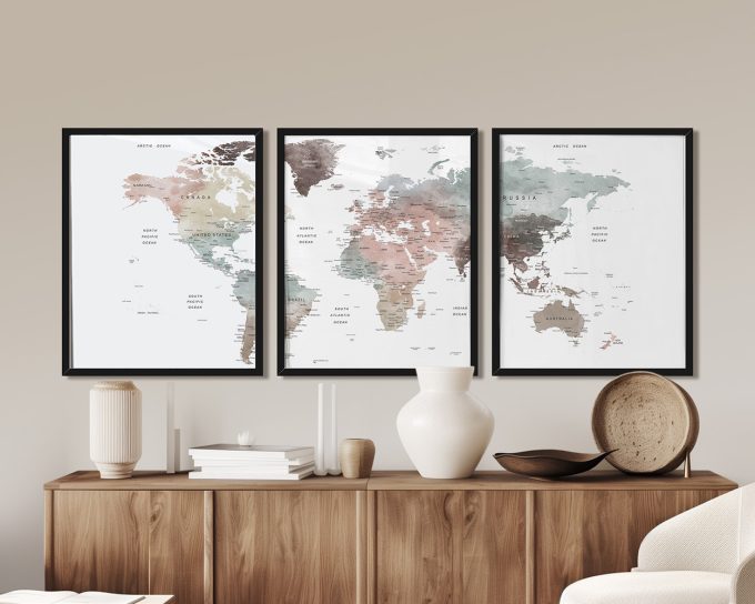 Three framed world maps displayed on a wall with a neutral background.